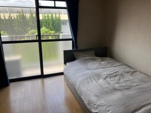 Postel nebo postele na pokoji v ubytování 豊前市国際交流会館