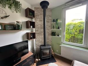 uma sala de estar com um fogão a lenha e uma janela em Le coin caché em Dijon