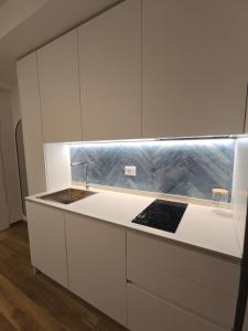 a kitchen with white cabinets and a sink at Casa Isabel Charm Apartment in San Benedetto del Tronto