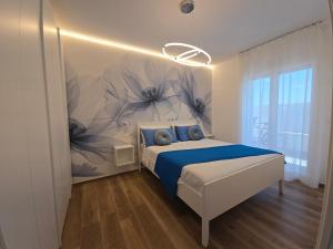 a bedroom with a bed with blue sheets and a flower mural at Casa Isabel Charm Apartment in San Benedetto del Tronto
