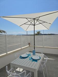 a table with an umbrella on a balcony at Casa Isabel Charm Apartment in San Benedetto del Tronto