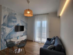 a living room with a blue couch and a table at Casa Isabel Charm Apartment in San Benedetto del Tronto