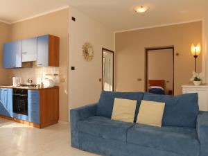 a living room with a blue couch and a kitchen at Appartamenti Casa La Rosa in Bellagio