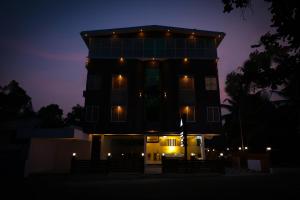 un bâtiment avec des lumières allumées la nuit dans l'établissement Delano Residency, à Kaliyal 16 autres photos
