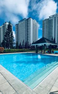 a swimming pool in front of some tall buildings at Tagaytay Staycation by SMDC WIND RESIDENCES LAKEVIEW in Kaybagal