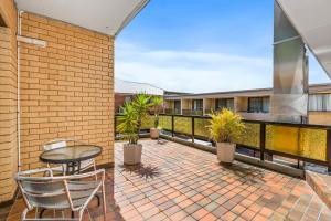 un patio con tavolo e sedie sul balcone. di Comfort Inn Centrepoint Motel a Lismore