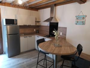 una cucina con un tavolo di legno e un frigorifero di Domaine Le Manège - Gite Le Tilleul, près d'Etretat a Sainte-Marie-au-Bosc Altre 7 foto