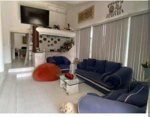 a living room with blue couches and a tv at Casa de los Soles in Oaxtepec