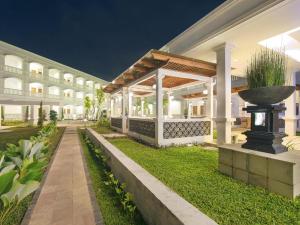 a large white building with a planter in the yard at Hotel Ammi Cepu in Cepu