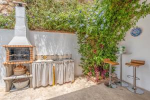 eine Terrasse mit einem Tisch mit Kamin und Weinreben in der Unterkunft Casa con Vistas a Sierra Nevada in Saleres