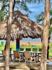 un groupe de tables et de chaises sous un parasol dans l'établissement The Beach House Ho Tram Resort, 