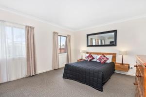 1 dormitorio con cama y espejo en la pared en Comfort Inn Centrepoint Motel, en Lismore