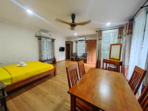 a living room with a bed and a dining room table at Desaland Tunas Hijau in Labuan