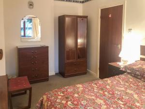 Un dormitorio con una cama, una cómoda y un armario. en Forge Mill Cottage, en Dalbeattie 9 fotos más