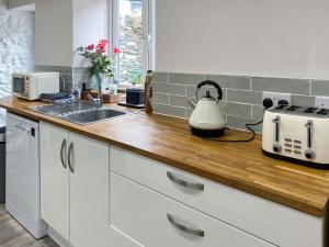 a kitchen counter with a toaster and a sink at 1 Bronrallt in Penmaen-mawr