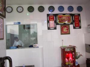 a restaurant with clocks on the wall and a man at Trung Luong Hotel 2 in My Tho