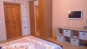 a living room with a television and a room with a door at Apartment Hokhryakova 21 City Center in Yekaterinburg