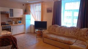 a living room with a couch and a kitchen at Apartment Hokhryakova 21 City Center in Yekaterinburg