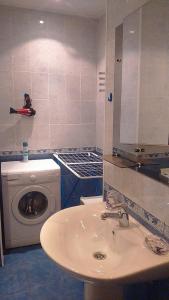 a bathroom with a sink and a washing machine at Apartment Hokhryakova 21 City Center in Yekaterinburg