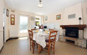 a dining room with a table and a fireplace at Beautiful Home In Andouillé-Neuville in Andouillé-Neuville