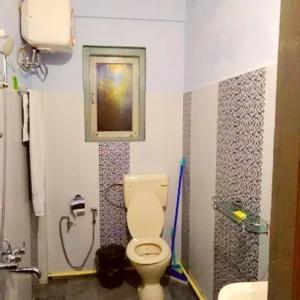un baño con inodoro y lavabo en Mension Inn, en Cherrapunji