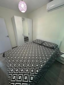 una camera da letto con un letto con un piumone bianco e nero di Морски Бриз a Lozenets