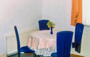 a table with blue chairs and a vase on it at Holiday Home Am Wiesengrund V in Löcknitz