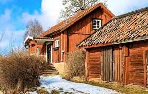 a wooden barn with snow on the ground next to it at Nice Home In Gnesta With Kitchen in Björnlunda +2 photos
