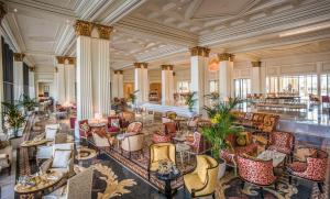 a lobby with tables and chairs in a building at Palazzo Versace Dubai in Dubai