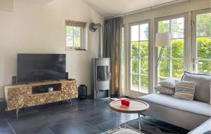 a living room with a couch and a flat screen tv at Buitengoed Het Lageveld - 52 in Hoge-Hexel