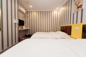 汉阳Weiyi Boutique Hotel的配有条纹墙壁的客房内的两张床
