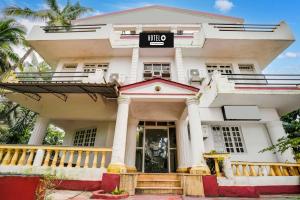 un grand bâtiment blanc avec une enseigne dessus dans l'établissement Hotel O Calangute, à Goa