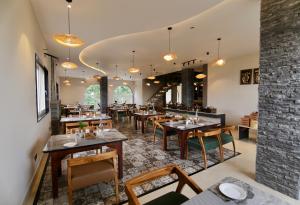 a restaurant with wooden tables and chairs and a brick wall at Q' Nest Hotel Cloud End Lansdowne in Lansdowne
