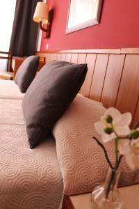 a bedroom with two beds and a vase with flowers on a table at Hostal Regina in Blanes