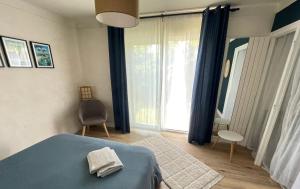 a bedroom with a blue bed and a window at Le 139' in Quimper