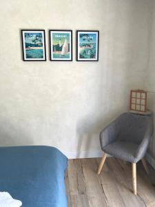 a room with three pictures on the wall and a chair at Le 139' in Quimper