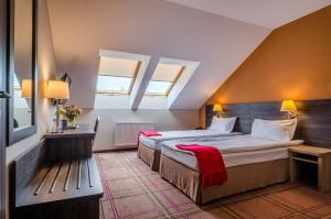 a bedroom with a large bed and two windows at Mikołajki Resort Hotel & Spa Jora Wielka in Mikołajki