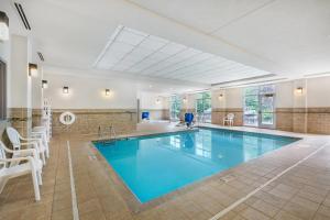 a large swimming pool with blue water in a building at Comfort Inn & Suites Dover in Dover