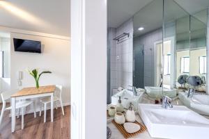 baño con lavabo, mesa y espejo en Studio Galé Terceiro, en Lisboa