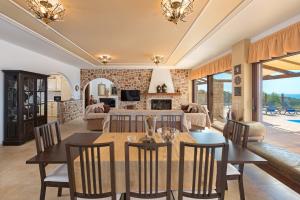 a dining room and living room with a table and chairs at Butterfly Villa in Theologos