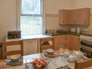 a kitchen with a table with plates of fruit on it at Sunnyside Hestbank in Hest Bank