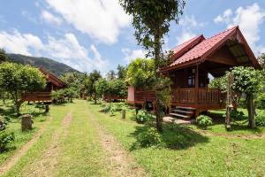 une maison au milieu d'un champ avec des arbres dans l'établissement OYO 1143 Phet Luran Thai Resort Kohchang, à Ko Chang