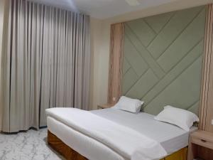 Un dormitorio con una gran cama blanca y una ventana. en شقق ابراج الخير, en Abha