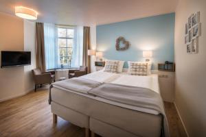 a bedroom with a large bed and a living room at Hotel kleine Auszeit - Adults Only in Sankt Peter-Ording