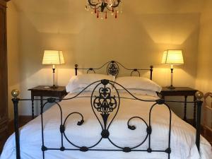 a bedroom with a black wrought bed with two lamps at May Cottage in Bakewell