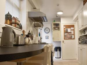 a kitchen with a counter and a clock on the wall at Flat 1 Garden View - Ukc4221 in Lowestoft