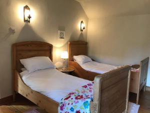 two twin beds in a room with two lamps at May Cottage in Bakewell