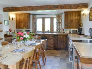 a kitchen with a long table with flowers on it at Townfield Farm in Chinley