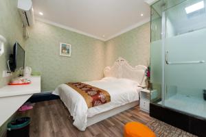 汉阳Weiyi Boutique Hotel的带床和玻璃淋浴间的卧室