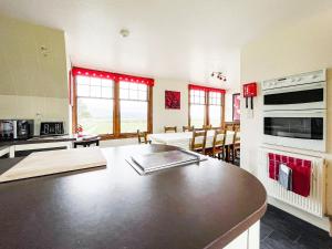 a kitchen with a counter top and a table in a room at Fourpenny Cottage - Uk34744 in Embo +10 photos